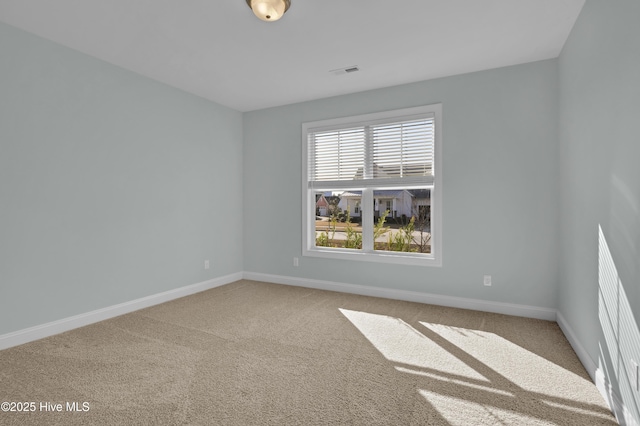 spare room with visible vents, baseboards, and carpet floors