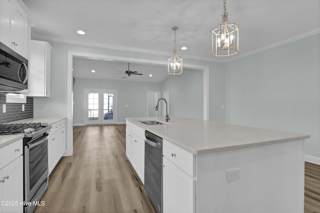 kitchen featuring a sink, stainless steel appliances, light wood-style floors, crown molding, and tasteful backsplash