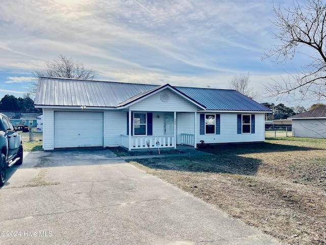 single story home with covered porch, a garage, and a front lawn