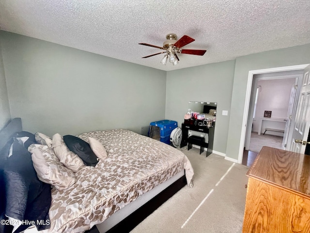 bedroom with ceiling fan, carpet floors, and a textured ceiling