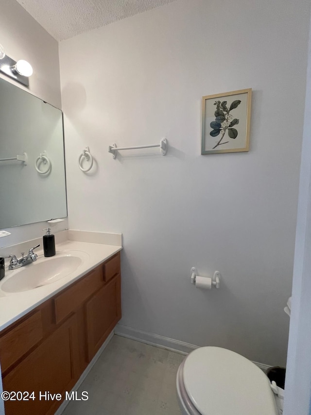 bathroom featuring vanity, a textured ceiling, and toilet