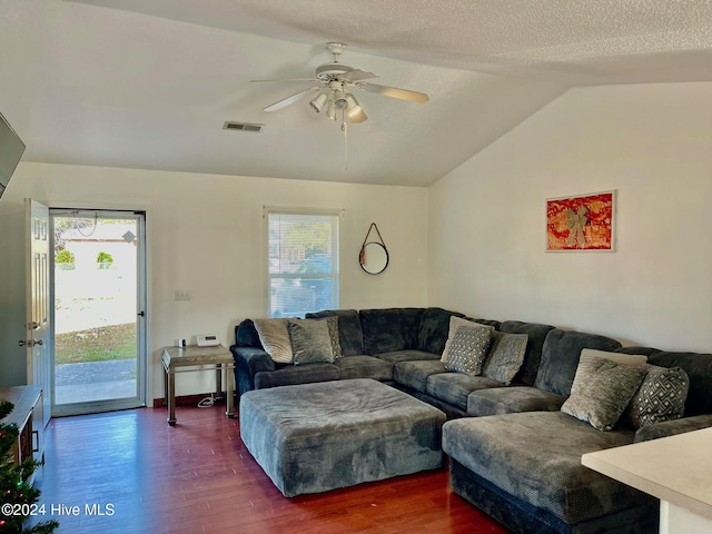 living room with lofted ceiling, a wealth of natural light, dark wood-type flooring, and ceiling fan