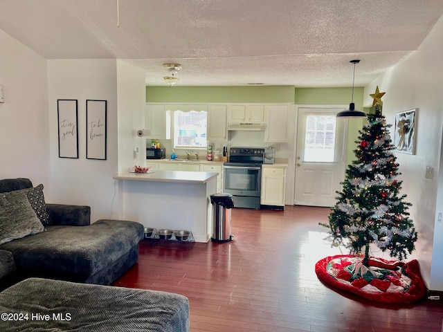 kitchen with decorative light fixtures, white cabinetry, stainless steel electric range oven, and kitchen peninsula