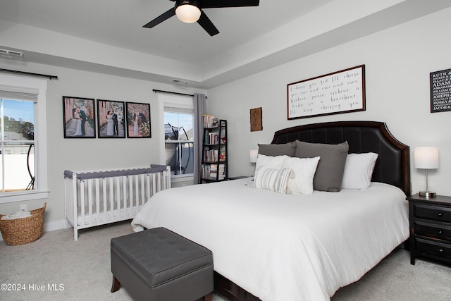 carpeted bedroom with multiple windows and ceiling fan