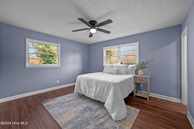 bedroom featuring a textured ceiling, dark hardwood / wood-style floors, and ceiling fan