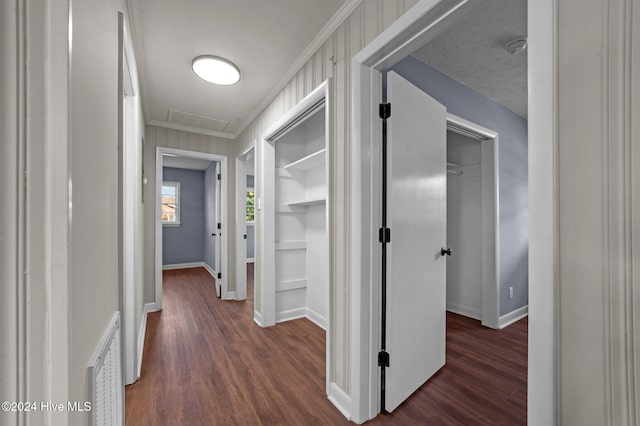 corridor with dark hardwood / wood-style floors and ornamental molding