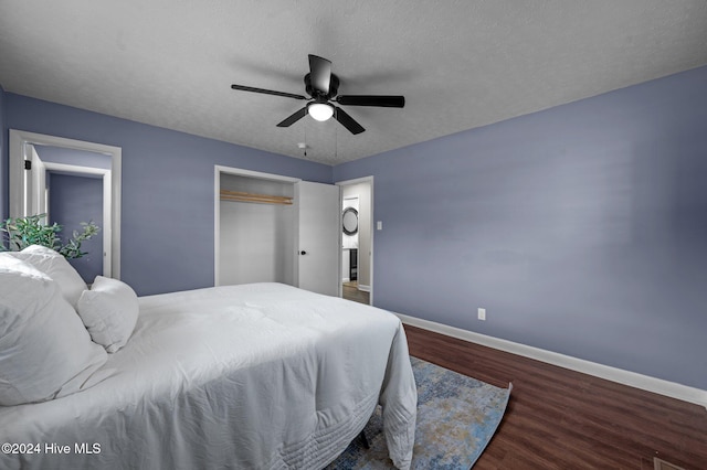 bedroom with a textured ceiling, ceiling fan, and dark wood-type flooring