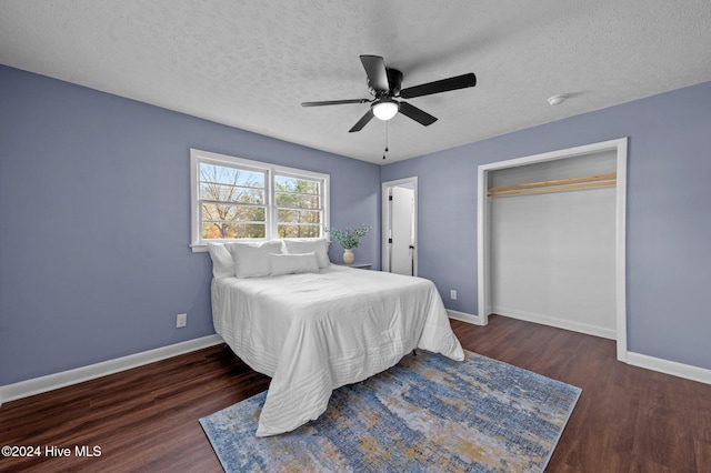 bedroom featuring a textured ceiling, ceiling fan, a closet, and dark hardwood / wood-style floors