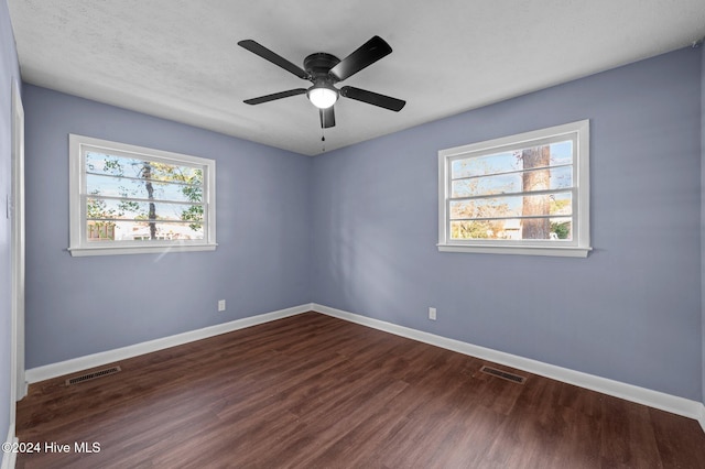 unfurnished room featuring ceiling fan, dark hardwood / wood-style flooring, and a textured ceiling