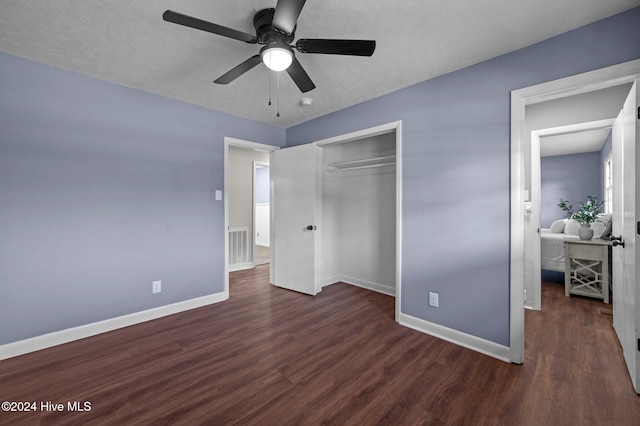 unfurnished bedroom featuring a textured ceiling, ceiling fan, dark wood-type flooring, and a closet