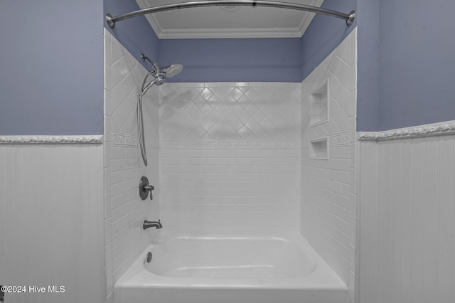 bathroom with crown molding and tiled shower / bath