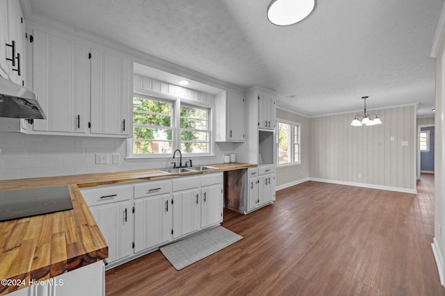 kitchen featuring white cabinets, wooden counters, decorative light fixtures, and a notable chandelier