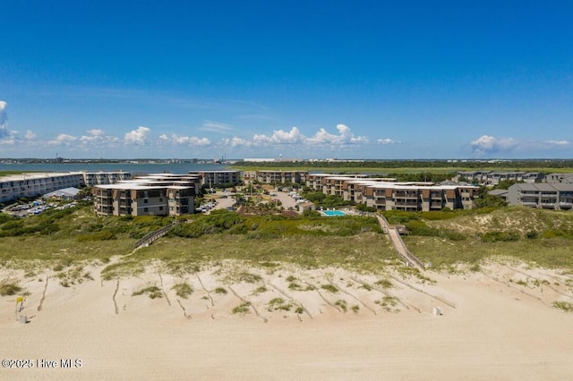 birds eye view of property featuring a water view and a beach view