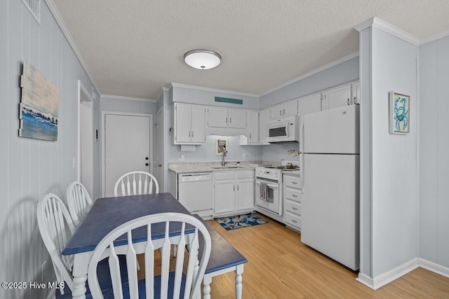 kitchen featuring sink, white cabinets, crown molding, white appliances, and light hardwood / wood-style flooring