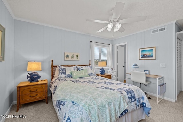 bedroom with crown molding, light carpet, a textured ceiling, and ceiling fan