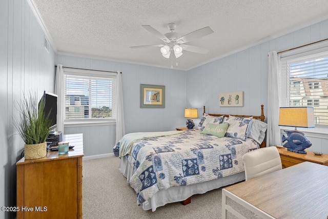 carpeted bedroom with ceiling fan, ornamental molding, and a textured ceiling