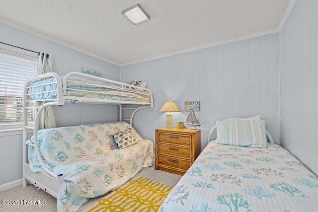 carpeted bedroom with crown molding, wooden walls, and a textured ceiling