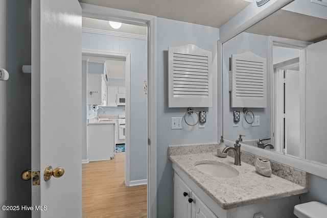 bathroom featuring hardwood / wood-style flooring, ornamental molding, and vanity