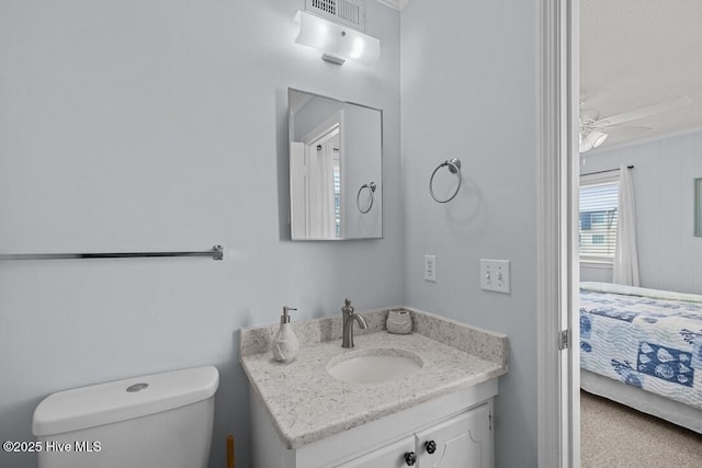 bathroom featuring vanity, toilet, and ceiling fan