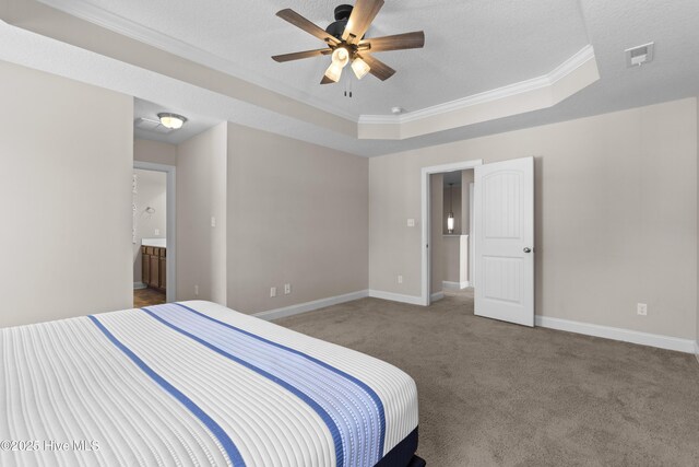 carpeted bedroom featuring ensuite bath, a textured ceiling, a raised ceiling, ceiling fan, and crown molding