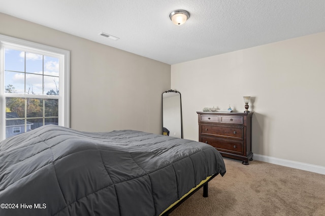 carpeted bedroom featuring a textured ceiling