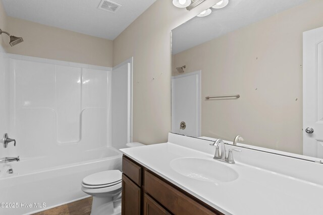 bathroom with a textured ceiling, vanity, and toilet