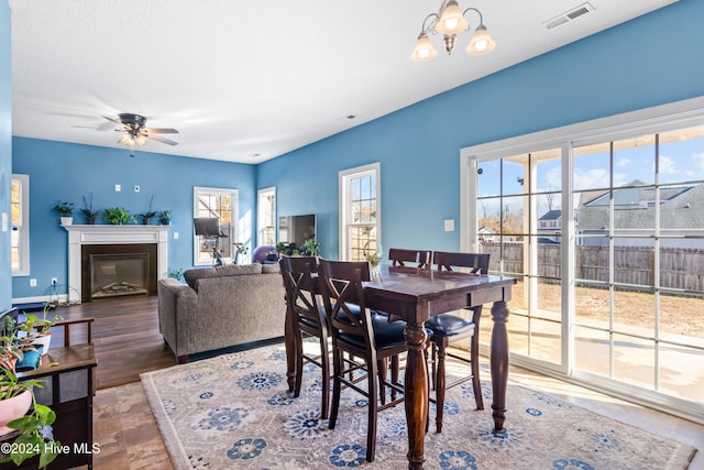 dining room with wood-type flooring and ceiling fan with notable chandelier