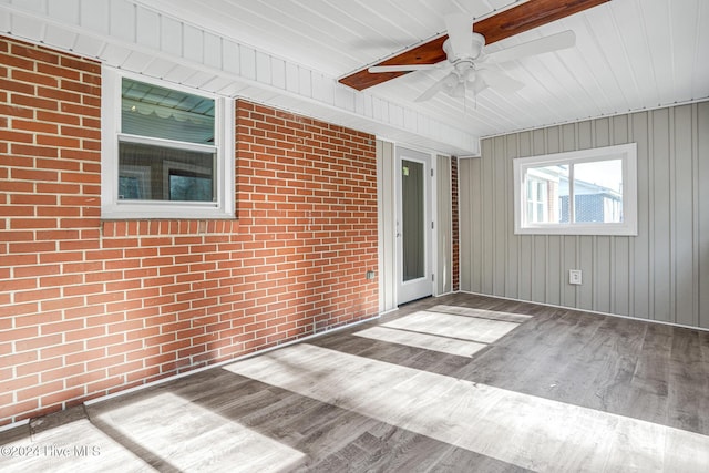 unfurnished sunroom featuring ceiling fan