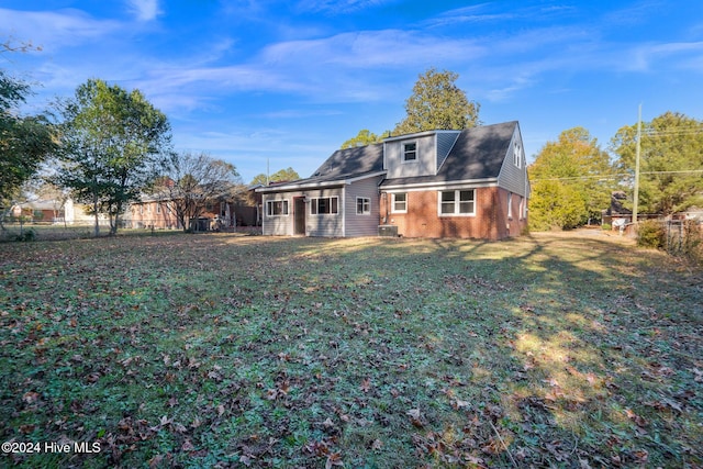 rear view of property featuring a yard