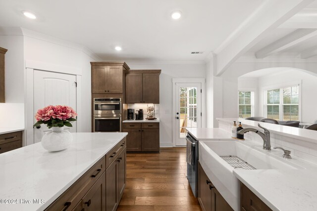 kitchen with sink, light stone counters, dark hardwood / wood-style floors, and stainless steel appliances