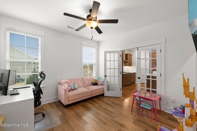 home office with hardwood / wood-style flooring, ceiling fan, and french doors