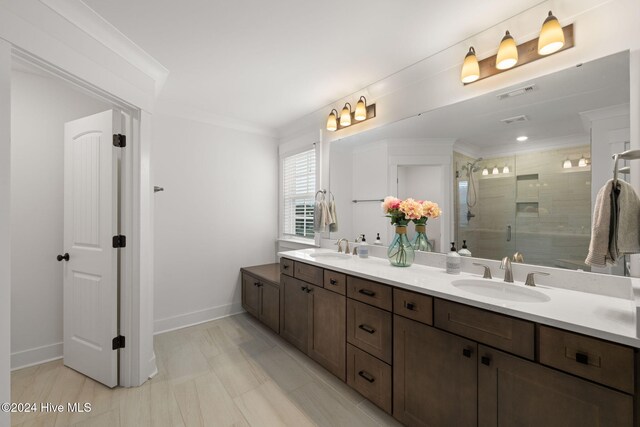 bathroom with an enclosed shower, vanity, and crown molding