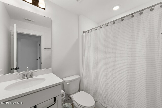 bathroom featuring vanity, toilet, and a shower with curtain