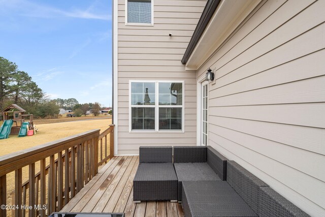 wooden deck with a playground and outdoor lounge area