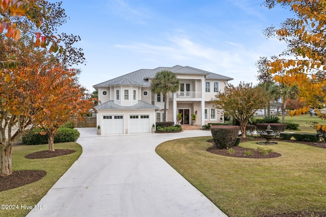 view of front of house featuring a balcony, a front yard, and a garage