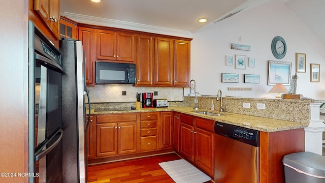 kitchen featuring kitchen peninsula, hardwood / wood-style floors, sink, and black appliances