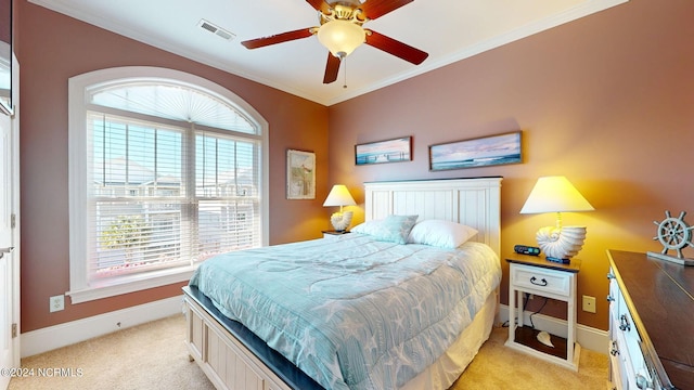 bedroom featuring ceiling fan, ornamental molding, and light carpet