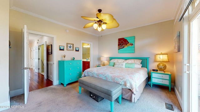 carpeted bedroom featuring ceiling fan, ornamental molding, and ensuite bathroom