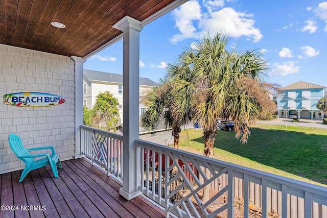 wooden terrace featuring a lawn