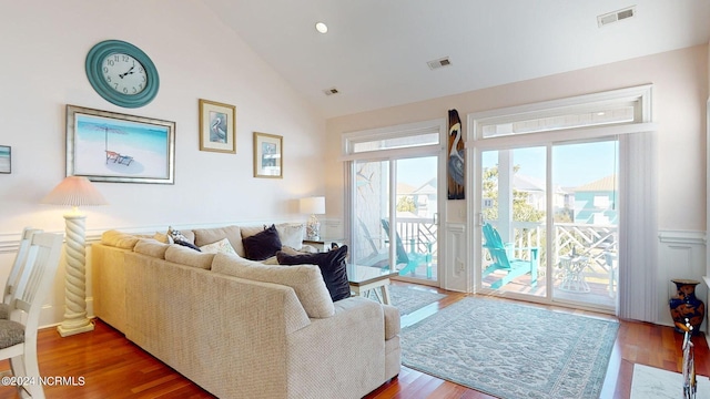 living room featuring plenty of natural light, vaulted ceiling, and hardwood / wood-style flooring