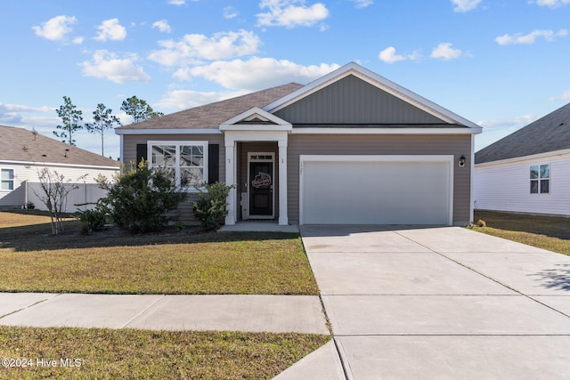 view of front of home with a front yard and a garage