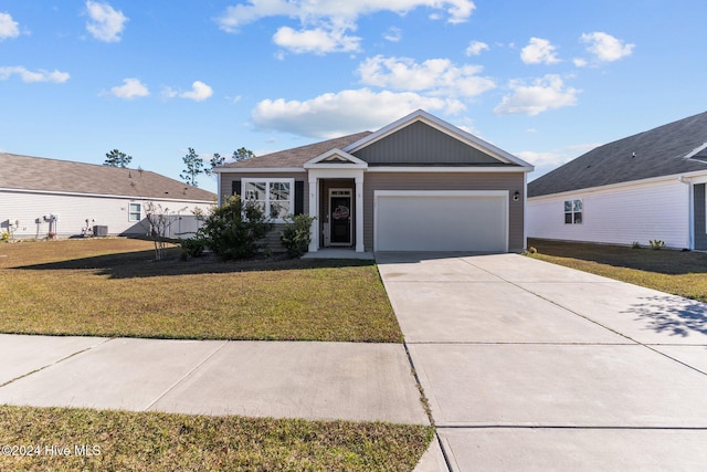 view of front of house with a garage, driveway, a front yard, and central air condition unit