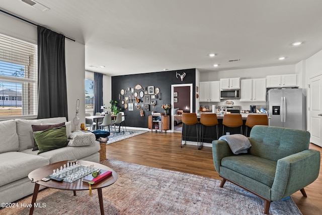 living area with visible vents, wood finished floors, and recessed lighting