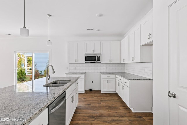 kitchen with light stone counters, dark hardwood / wood-style flooring, white cabinets, and decorative light fixtures