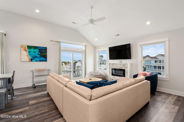 living room featuring dark hardwood / wood-style floors, a stone fireplace, and a wealth of natural light