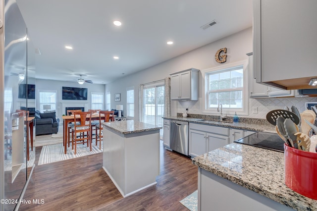 kitchen featuring a wealth of natural light, dishwasher, a kitchen island, and sink