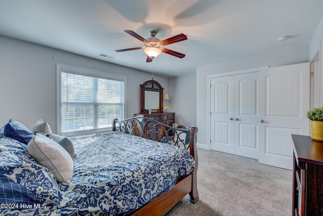 bedroom featuring ceiling fan, a closet, and light carpet