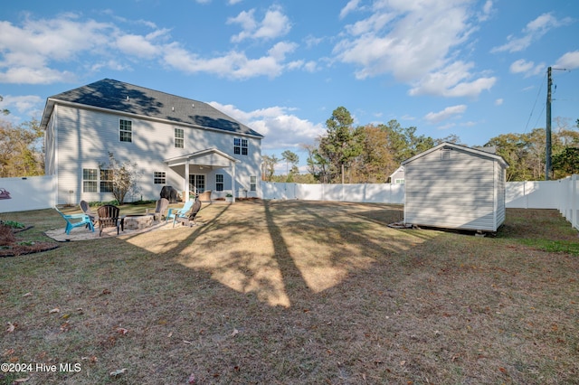 back of house with a patio area, a yard, and a storage unit