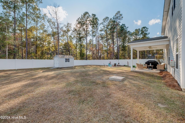 view of yard featuring ceiling fan and a storage shed