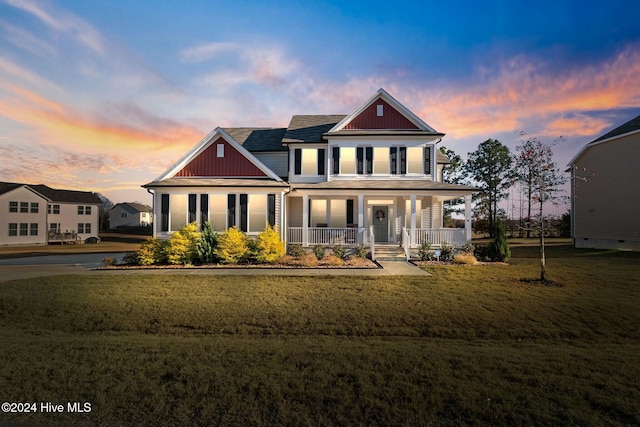 view of front of house featuring a porch, a yard, and board and batten siding